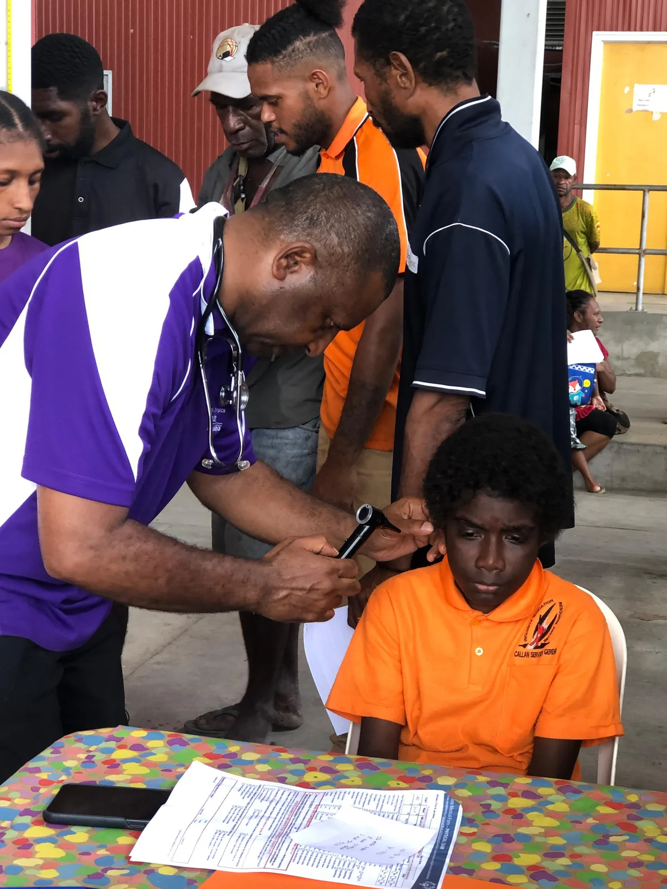 A health worker supports an athlete during a community check-up